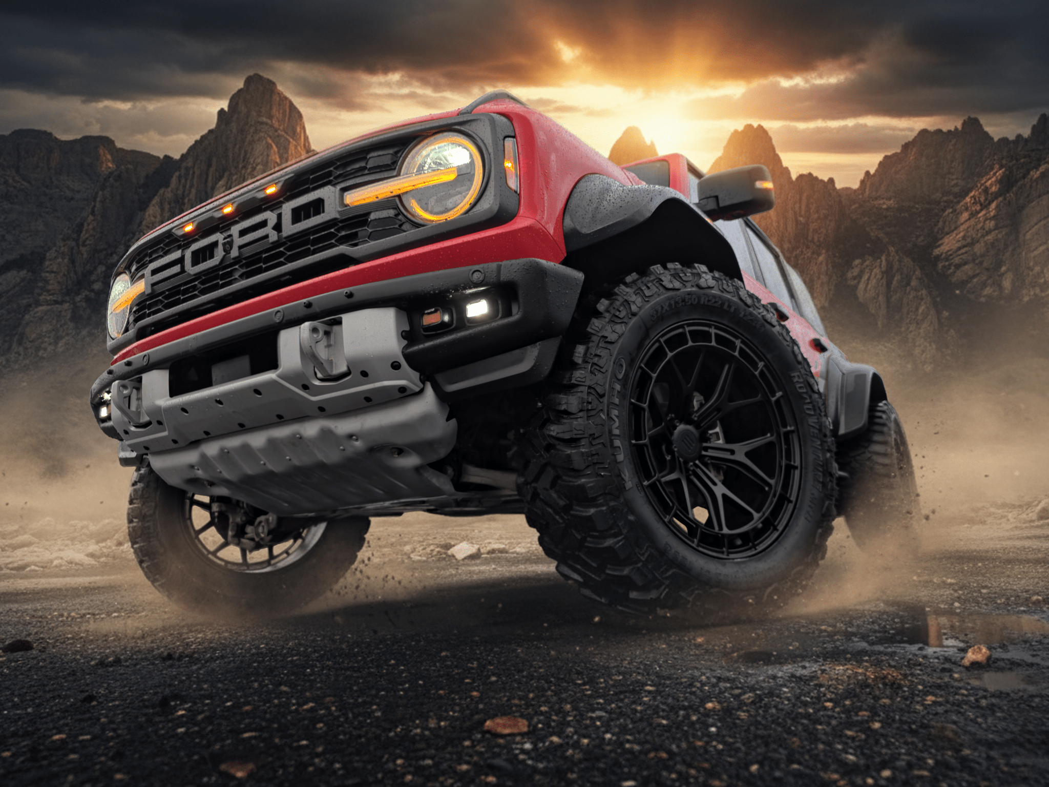 Ford truck driving on a dirt road with a dramatic sky and mountains in the background