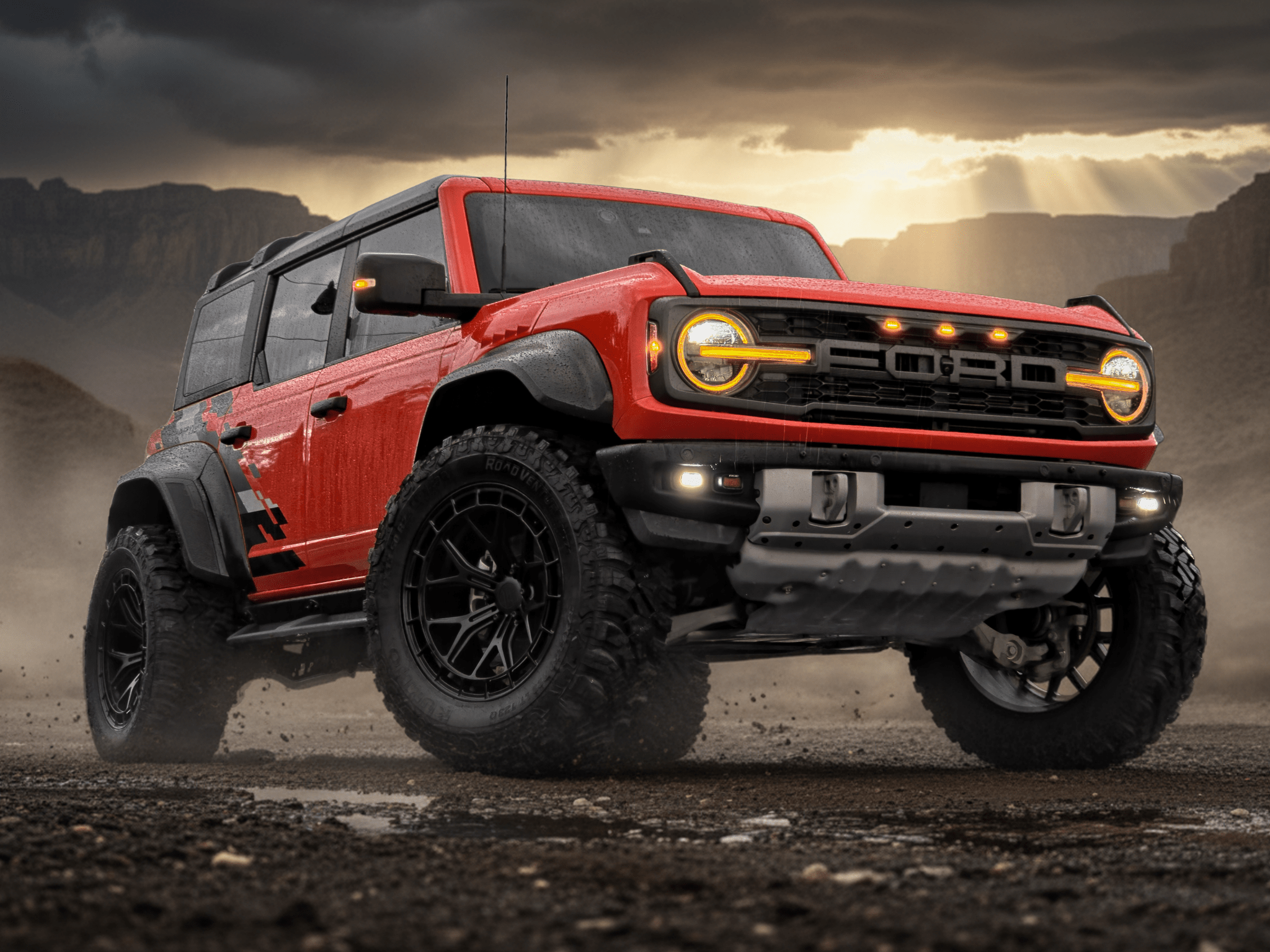 Red Ford truck on a desert landscape with dramatic sky